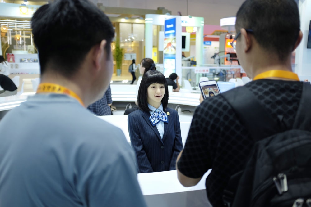 9月1日，媒體記者在國家會議中心與服務(wù)機(jī)器人互動。新華社記者 劉夢琪 攝