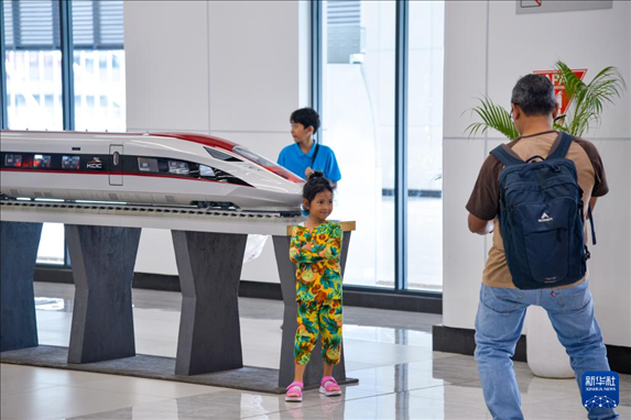 1月24日，在印度尼西亞雅加達哈利姆站候車大廳，一名小朋友和雅萬高鐵高速動車組模型合影。新華社記者 徐欽 攝