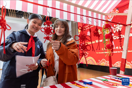 1月28日，復(fù)旦大學(xué)第二附屬學(xué)校學(xué)生（左）為美國(guó)馬斯卡廷中學(xué)學(xué)生（右）介紹中國(guó)結(jié)。 新華社記者 王翔 攝