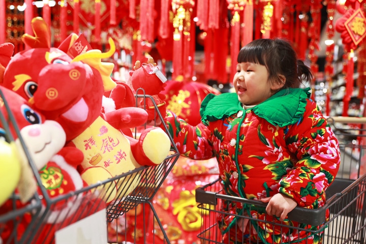 1月23日，在貴州省黔東南苗族侗族自治州岑鞏縣一家超市，小朋友在家人的帶領(lǐng)下選購龍年毛絨玩具。新華社發(fā)（唐鵬攝）