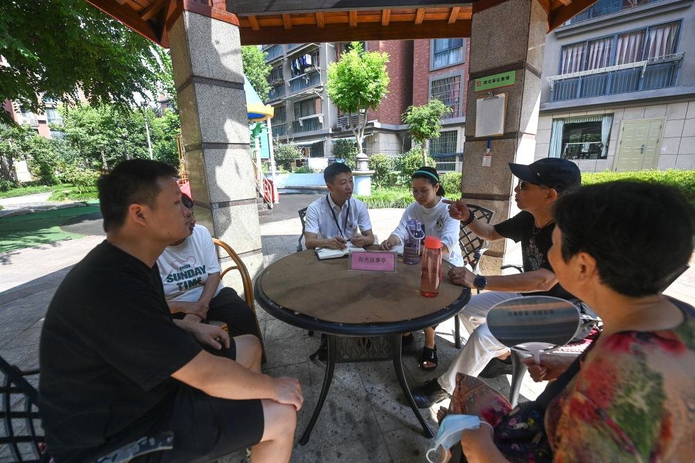 △2023年7月21日，在位于浙江杭州臨安區(qū)錦南街道水岸陽光小區(qū)的陽光議事廳，街道干部在聽取居民們反映的問題及意見。