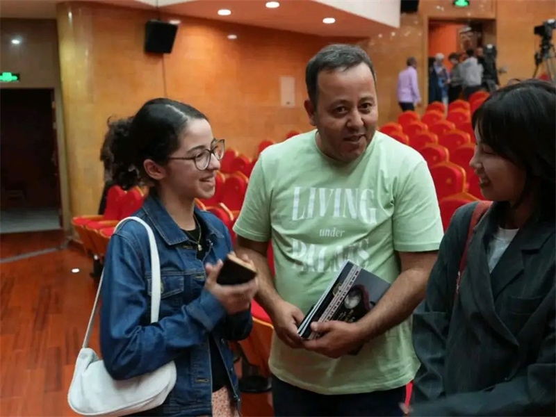 阿爾及利亞市民拉納·艾薩尼和她父親現(xiàn)場聆聽中阿交響樂演出 。蘇州交響樂團(tuán)供圖