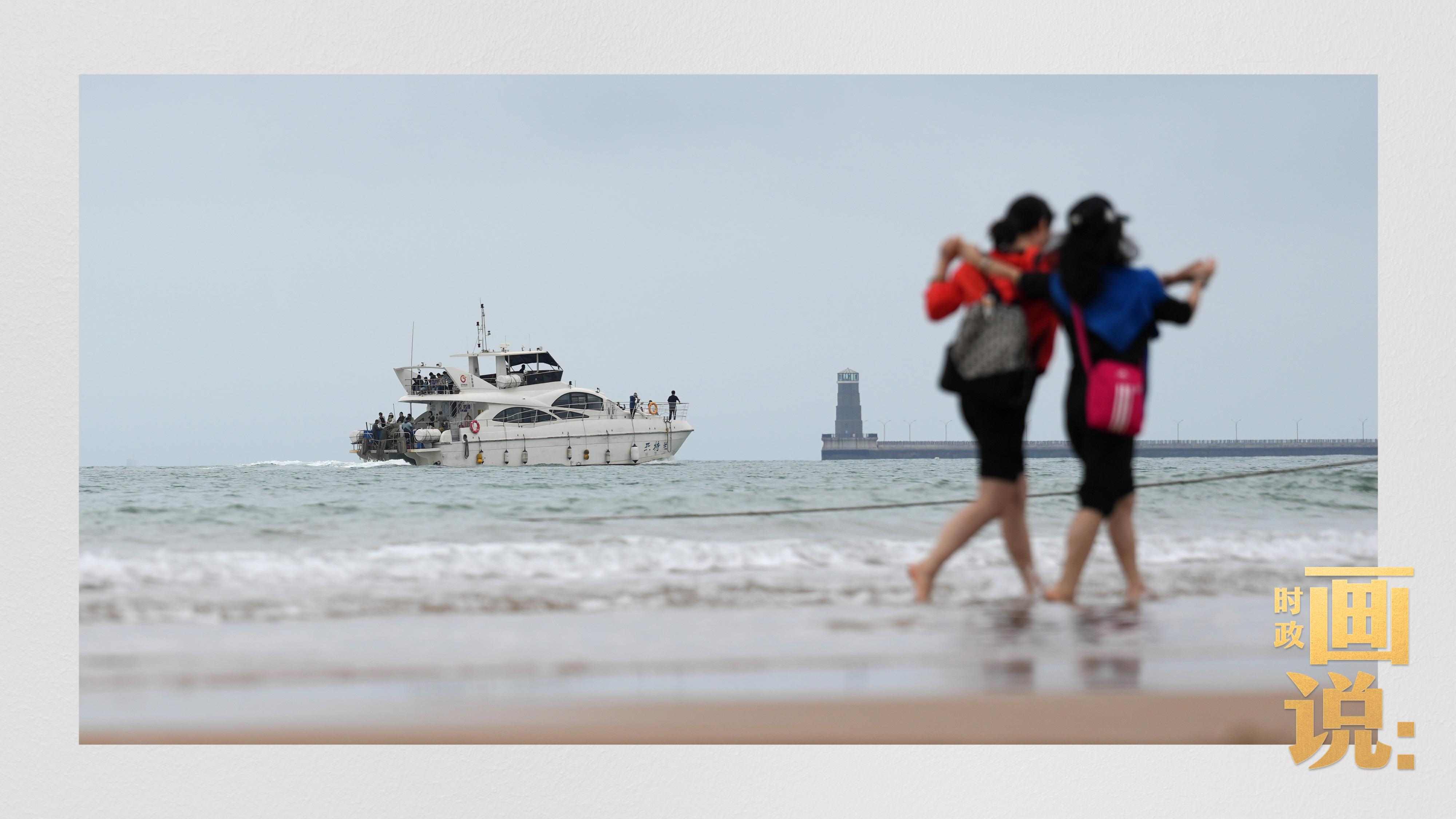 △日照陽光海岸綠道上的萬平口景區(qū)，一對游客在海浪中翩然起舞。