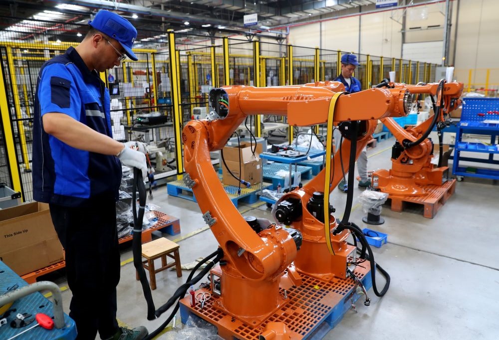 工作人員在上海新時(shí)達(dá)機(jī)器人有限公司位于嘉定的智能工廠內(nèi)忙碌（2024年5月23日攝）。新華社記者 龔兵 攝