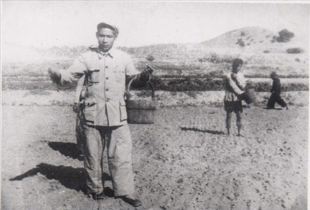 谷文昌（左）在田間與農(nóng)民一起勞動(dòng)（資料照片）。