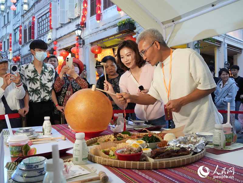 嘉賓品嘗海南傳統(tǒng)美食“煎堆”。人民網(wǎng)記者 張力洋攝