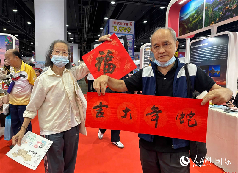 2025蛇年春節(jié)，泰國市民展示他們領到的華人手寫春聯(lián)。人民網(wǎng)記者 簡承淵攝
