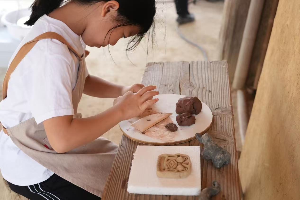 游客制作良渚特色陶藝品。良渚博物院供圖