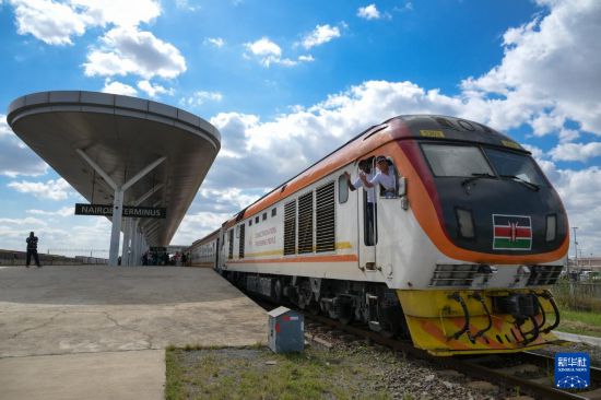 5月31日，在蒙內鐵路內羅畢站，機車駕駛員蔣立平（右）和博爾在即將開往蒙巴薩的E2次列車上揮手致意。新華社記者 楊光 攝